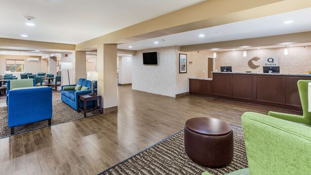 A hotel lobby with a reception desk, seating area with sofas, and a wooden floor. - Comfort Inn Charleston South (Charleston)