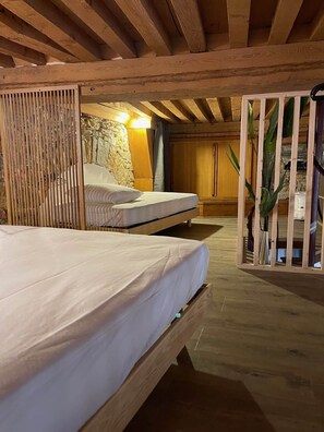 Une pièce en bois avec un lit, un mur en pierre et une porte en bois.