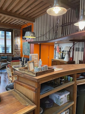 Une table à manger en bois avec un îlot central, entourée de chaises et d’un espace cuisine comprenant des placards et des appareils électroménagers.