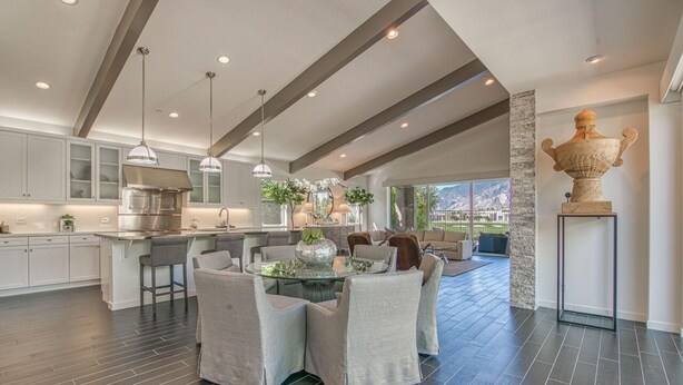 A spacious kitchen with a central island, pendant lighting, and a large decorative urn.