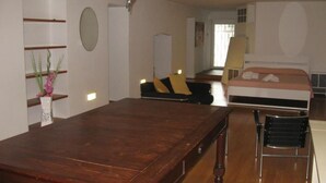 A bedroom with a wooden bed, a chair, a desk, and a mirror. - Ambra - Central Apartment in Bergamo (Bergamo)