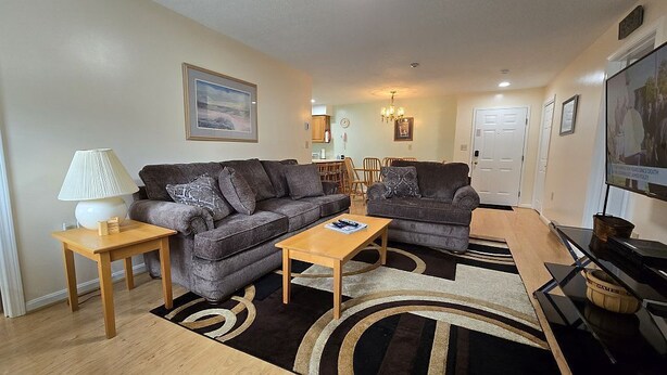 A living room with two sofas, a coffee table, a lamp, and a TV. - Mt Views from #238 Two Bedroom Condo (Lincoln)