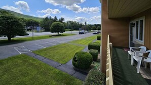 A view from a balcony overlooking a parking lot with a building in the foreground. - Mt Views from #238 Two Bedroom Condo (Lincoln)