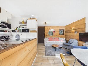 Eine moderne Küche mit weißen Schränken, einer Holz Arbeitsplatte und einem hängenden Drahtgestell.