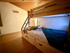 2 dormitorios y tabla de planchar con plancha