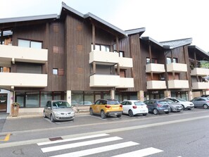 Un immeuble à plusieurs étages doté d’une architecture moderne, avec des balcons et de grandes fenêtres.