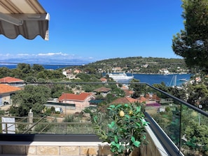 A balcony with a view of a coastal town, a ship named 'KOROLINJA,' and a statue. - Premium 2BR Sea-View Apartment with Huge 48m² Private Terrace – Rogač (Grohote)