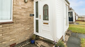 A white caravan with a glass door and a small porch area. - Sea Snug (Berwick-upon-Tweed)