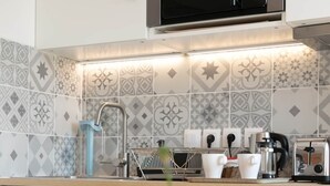 A modern kitchen with white cabinets, a microwave, a coffee maker, and a toaster. - Duplex with terrace - hyper-center of Toulon (Toulon)