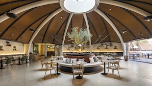 Un vaste espace de restauration intérieur, doté d’un aménagement centralisé des sièges, d’un haut plafond en arc et d’une grande verrière.