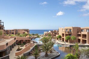 Ein Resort mit Pool, Palmen und Meerblick.