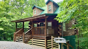 A wooden cabin with a porch and stairs leading to a deck. - 1BR-hot tub-pool table-close to Dollywood (1 free ticket)! (Sevierville)