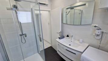 Een douche, een haardroger, handdoeken, shampoo