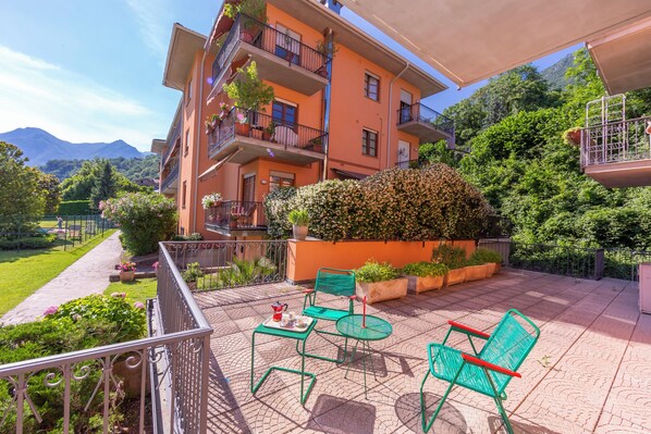 A balcony with outdoor furniture and a view of a mountain.