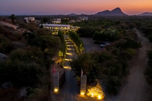 An aerial view of a property with a pathway leading to a building, surrounded by greenery and a mountain in the background. - Cheetagarh Resort & Spa (Bali)