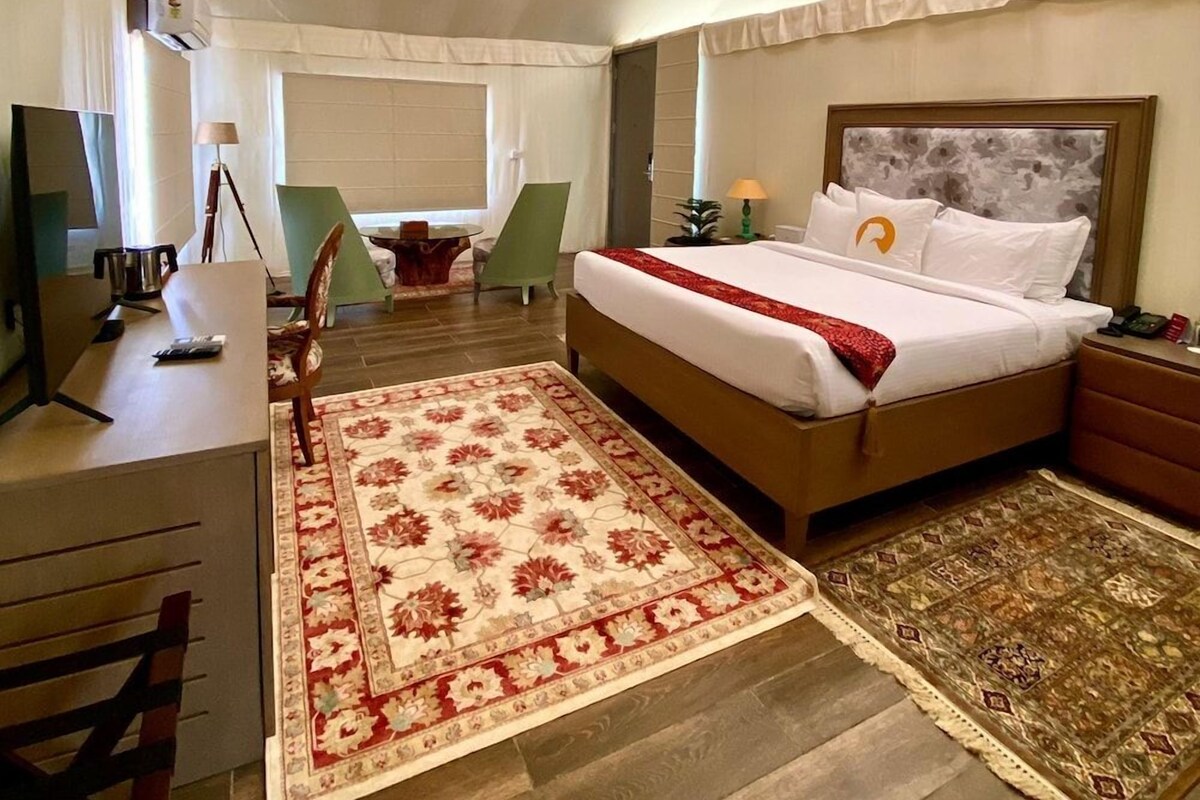 Une chambre spacieuse avec un grand lit, un bureau et une chaise.