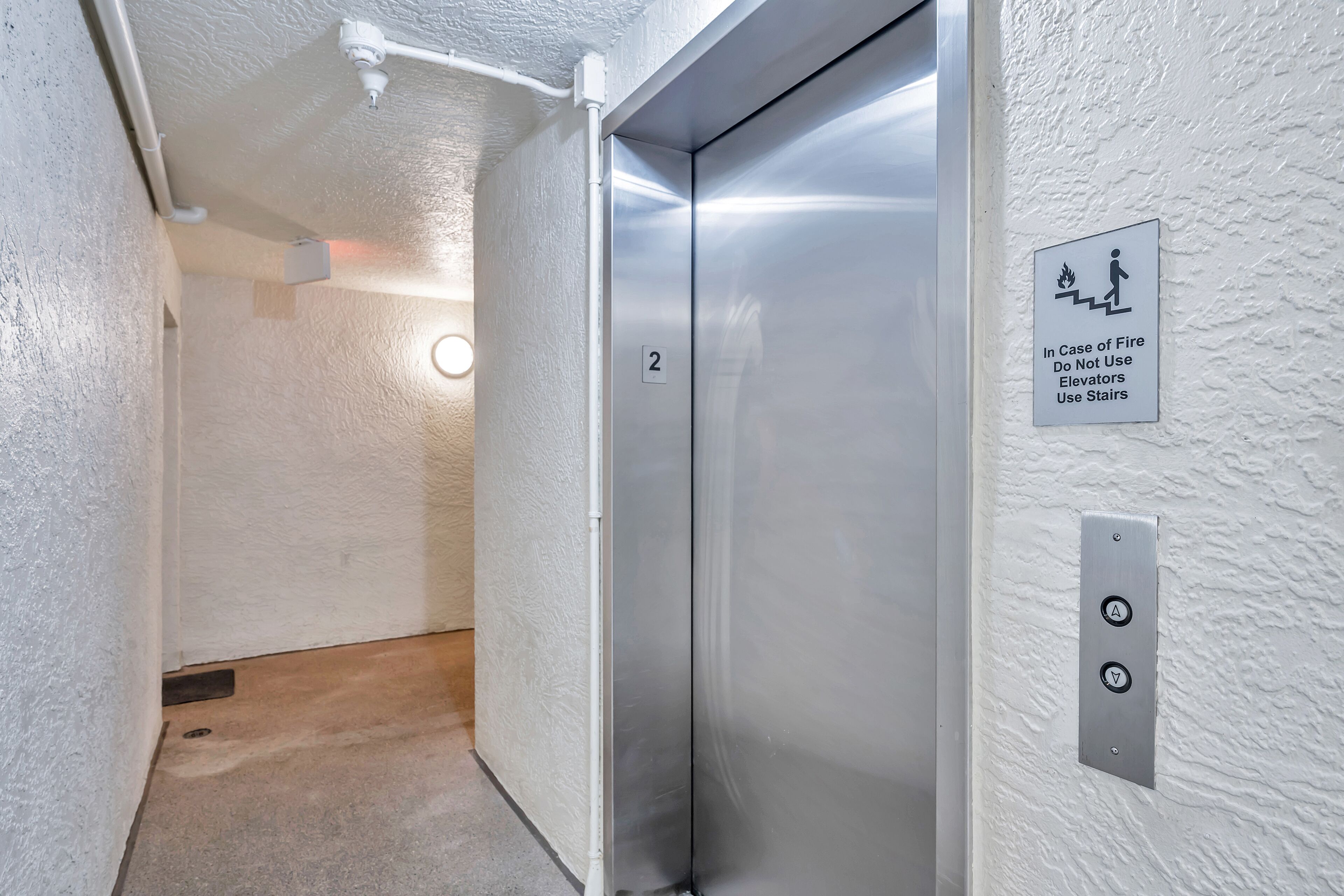 Un ascenseur muni d’un panneau indiquant qu’il faut utiliser les escaliers en cas d’incendie.
