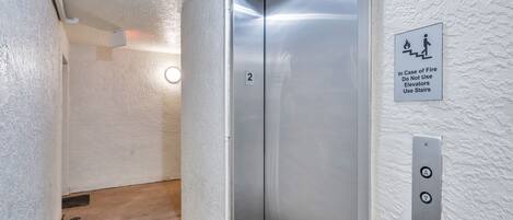 Un ascenseur muni d’un panneau indiquant qu’il faut utiliser les escaliers en cas d’incendie.