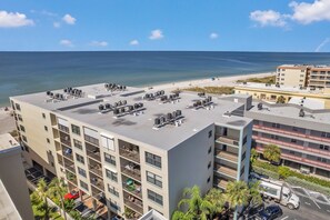 Un hôtel à plusieurs étages doté d’une terrasse sur le toit, d’un parking et offrant une vue sur la plage.