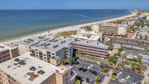 Eine Küstenlandschaft mit Strand, Gebäuden und einem Parkplatz.