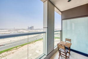 A balcony with a view of a highway and buildings.