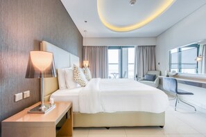 A modern hotel room with a large bed, bedside tables, a desk, and a chair. - Cool Dubai Apt next Burj Khalifa & Design District (Dubai)