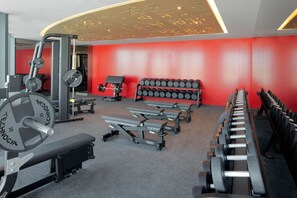A gym with weightlifting equipment, benches, and dumbbells. - Cool Dubai Apt next Burj Khalifa & Design District (Dubai)
