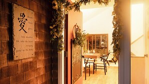 A wooden interior with a brick wall, a chalkboard with writing, and a wooden table with chairs. - Cape Cod Villa pond front vacation home, retreat, spa, venue, film location (Harwich - Brewster Border)