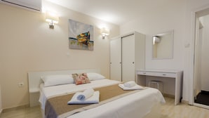 Ein Hotelzimmer mit Bett, Schreibtisch, Spiegel und einem Gemälde an der Wand.