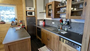 Une cuisine moderne avec des meubles en bois, un plan de travail en acier inoxydable et un four encastré.