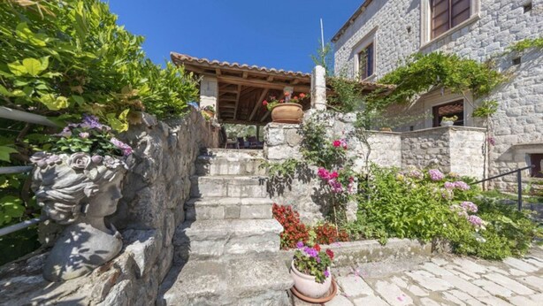 A stone building with a tiled roof, a stone staircase, and potted plants. - Villa Gradi (Dubrovnik)