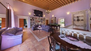 A spacious living room with a pool table, a sofa, a bookshelf, and a fireplace. - Villa Gradi (Dubrovnik)
