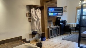 A room with a hot tub, a television, a coffee machine, and a seating area. - Country Suite - Private HotTub, KingBd, Downtown (Wolfville)