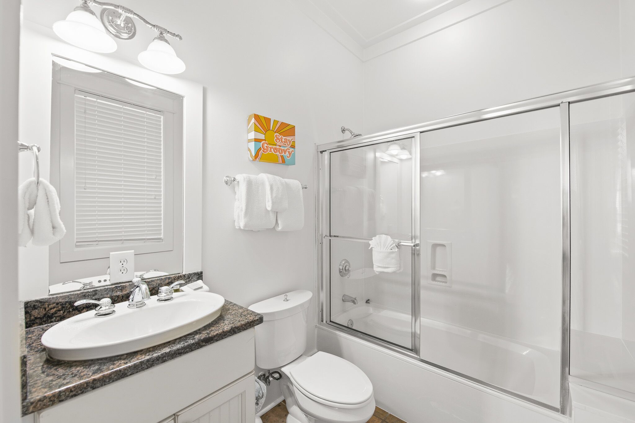 A bathroom with a sink, toilet, and glass-enclosed shower.