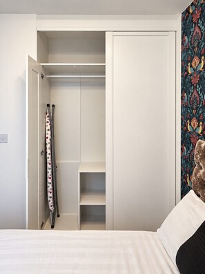 A bedroom with a bed, a wardrobe, and a bathroom with a shower curtain. - 2 Bedroom Central Apartment  (Liverpool)
