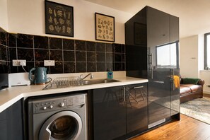 Una cocina moderna con lavadora integrada, un fregadero y lavavajillas.