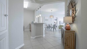 A spacious kitchen with a central island, a dining area with a table and chairs, and a decorative wall piece.