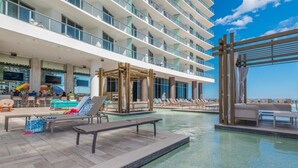 A pool area with lounge chairs, a wooden deck, and a view of the ocean. - Hyde Side Ocean View 1 Bedroom Condo by RedAwning (Hollywood)
