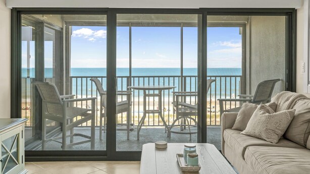 A balcony with a view of the beach, a sofa, and a table with decorative items. - Oceana 1-Upgraded 2 Bedroom Ocean Front Oceana Condo with Outdoor Pool! (Ocean City)