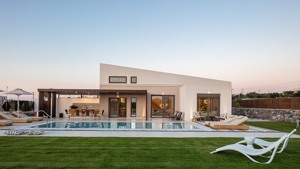 Une maison moderne dotée d’une piscine, d’un espace extérieur aménagé et d’une pelouse bien entretenue.