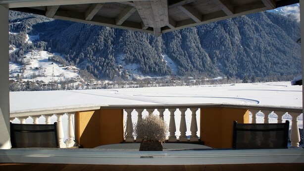 A balcony with a view of a snowy mountain landscape. - Winter dream vacation apartment in the Zillertal in direct proximity to the Horbergbahn ski lift (Schwendau)