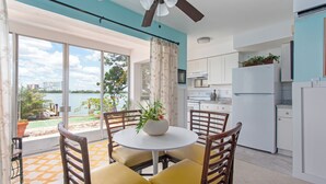 A modern kitchen with white cabinets, a white refrigerator, and a ceiling fan. - Front-Row Waterfront Escape – 1BR Condo on Clearwater Beach (Clearwater Beach)
