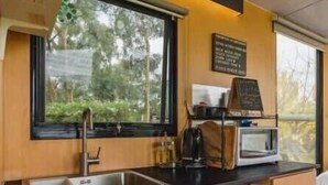 Una cocina moderna con un amplio ventanal, microondas integrado y un refrigerador.