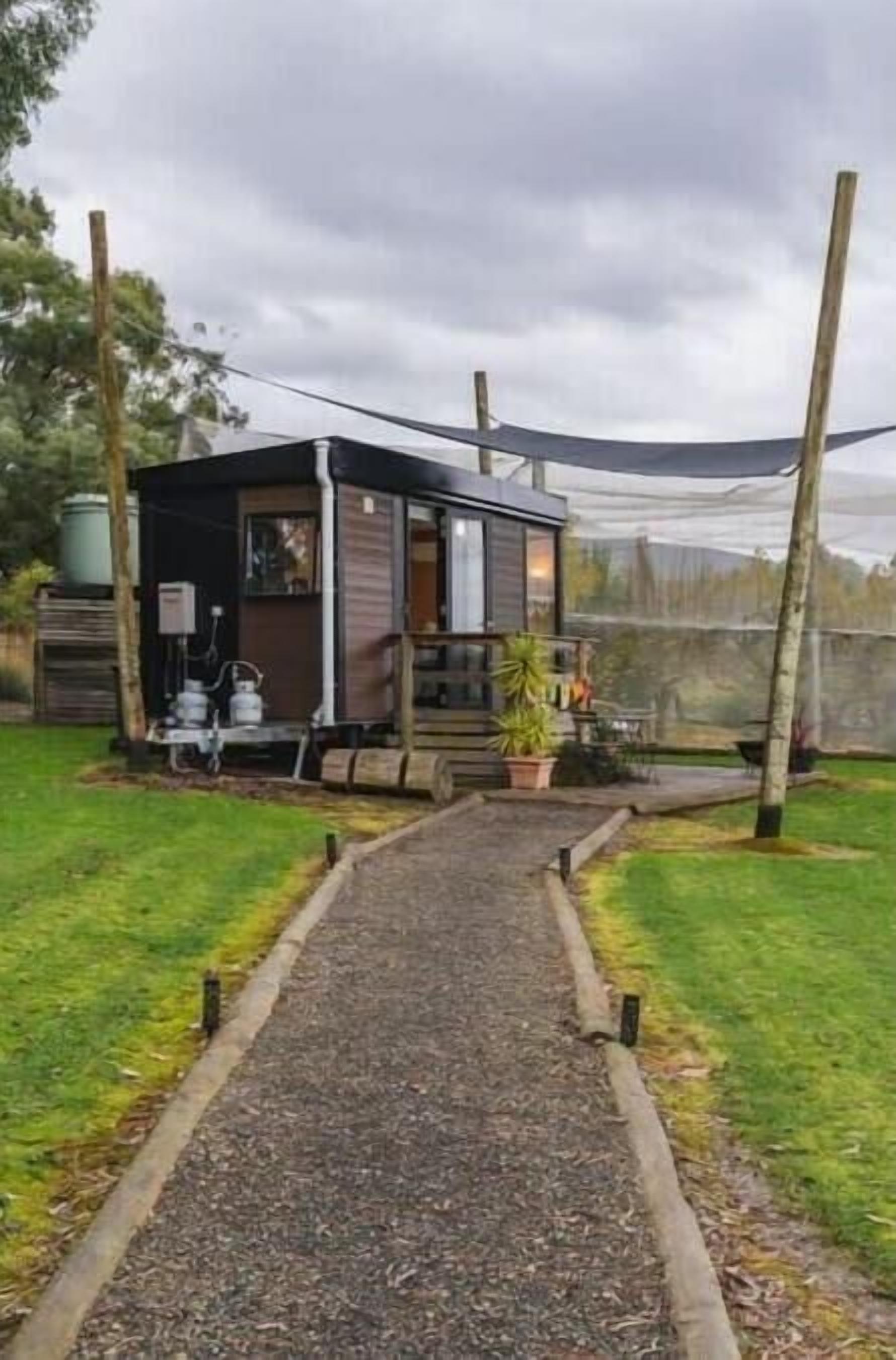 A modern, compact house with a gravel pathway leading to the entrance.
