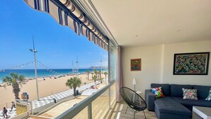 A balcony with a view of a beach, a sofa, a chair, and a table. - GEMELOS 1 MODERN SEAVIEWS R084 (Benidorm)