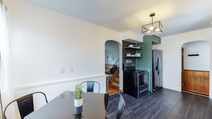 A modern kitchen with dark wood flooring, a built-in oven, and a stainless steel refrigerator. - Home of Champions: HOF Village Comfort (Canton)