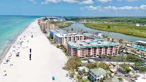 Un hotel sulla spiaggia con diversi piani, una piscina e vista sulla spiaggia e sul fiume.