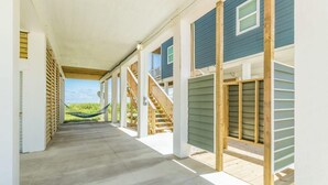 A covered porch with a view of a green field. - Stunning Ver La Mer - Direct Ocean & Beach Access! (Surfside Beach)