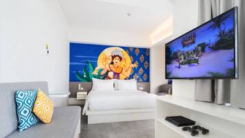 Una camera d'albergo moderna con un letto, una TV, un divano e un murale.