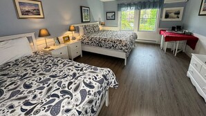 A bedroom with two beds, a desk, and a ceiling fan. - Port Williams Room -KingBed, Patio, Downtown (Wolfville)